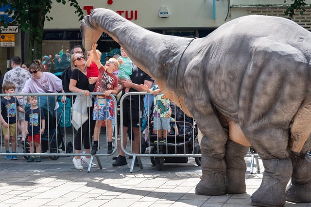 Emily Bronty the Brontosaurus entertains the crowds in Lancaster city centre as part of Dino Fest 2023.