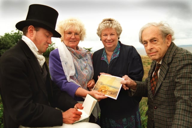 Turner alias actor Daley Donnelly, checks the correctness of  his painting of Heysham village, which is the latest Turner postcard to be released by Heysham Heritage Association, to commemorate Turner Week, with councillor Jean Yates, association secretary and treasurer, Barbara Verhoef and committee member John Procter. (1996).