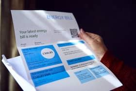 Woman opening UK energy bill concerned about cost of living energy crisis.