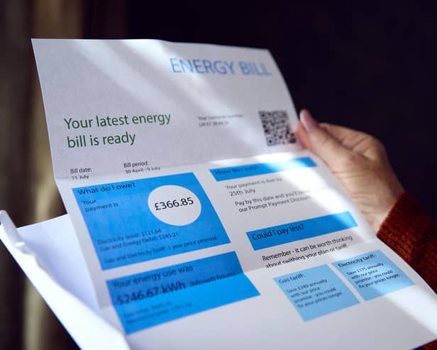 Woman opening UK energy bill concerned about cost of living energy crisis.