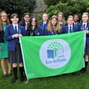 Miss Bradshaw, some of the Eco-Council and Eco-Club members and Mrs Potter proudly display their Eco-Schools Green Flag.