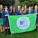 Miss Bradshaw, some of the Eco-Council and Eco-Club members and Mrs Potter proudly display their Eco-Schools Green Flag.