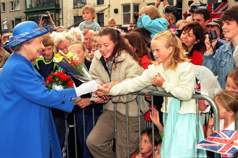 A young girl hands flowers to the Queen during her visit to Morecambe in 1999.