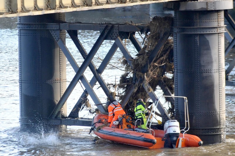 Clearing debris from a stanchion of the Greyhound Bridge.