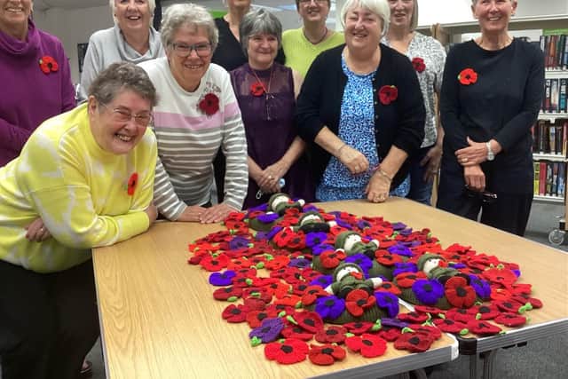 Poppy pride: The proud knitters show off their handiwork to Lara McDonnell, centre back row, from FirstLight Trust. Picture: Ken Bennett
