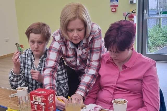 A Westmorland Homecare Team Leader (centre) colouring in Easter eggs with two clients