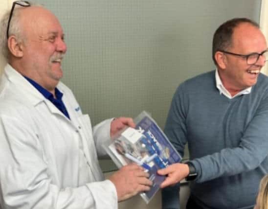 A team member receives an ownership pack from managing director Paul Bailey.