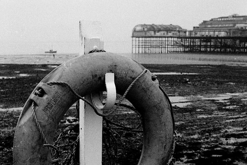 A lifebuoy on the promenade in Morecambe with Central Pier in the background.