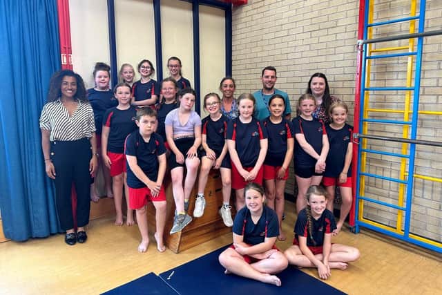 Members of the Mossgate Primary School gymnastics club with Jamilah Hassan (left)  of The Banks Group, teaching assistant Christine Wright (back right), headteacher Rob Smith and bursar Katie Turnbull