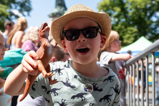 Leo, five, with his toy dinosaur as he awaits Zeus the giant T-Rex in Dalton Square.