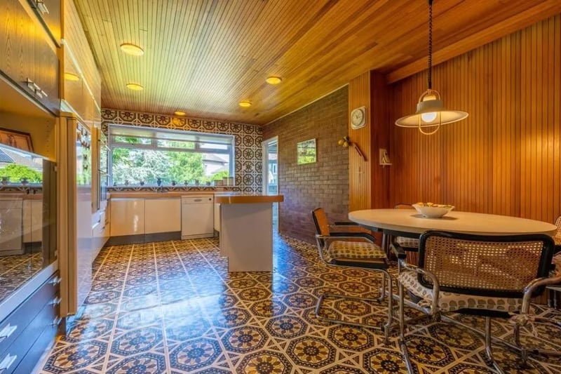 The stunning kitchen has Amtico tiled floor and walls, feature wooden panelling and a brick wall.