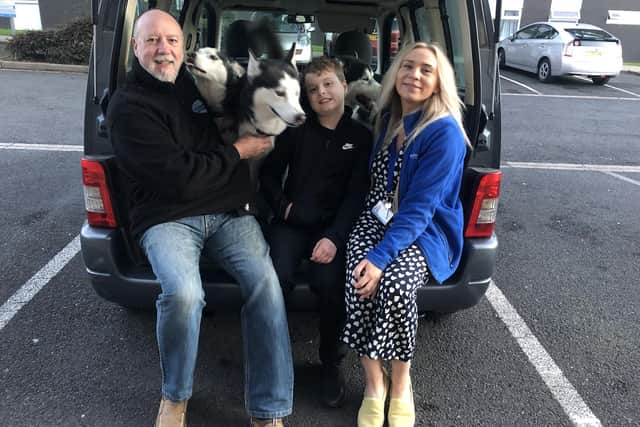 One good turn deserves another for Corey, who is now looking forward to an adventure with Martin (left), of Husky Adventures UK, and his husky team, which came to greet Corey at Rosemere Cancer Centre when he presented his donation to charity Rosemere Cancer Foundation’s community fundraiser Yvonne Stott.