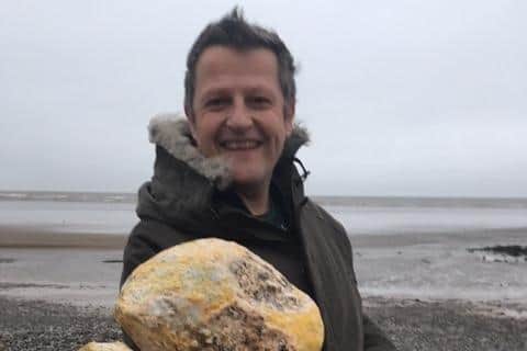 Jonathan Pearson with the waxy yellow rock he found on Morecambe beach which he hopes is potentially valuable whale vomit.