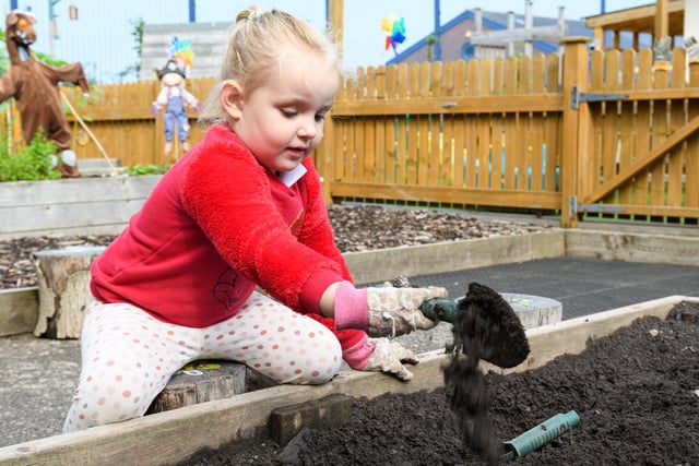 A Mossgate Day Nursery pupil plays with soil.