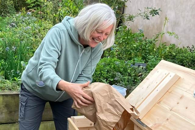 Sharon, a member of the community composting scheme, emptying her food caddy