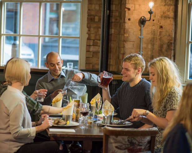 Customers enjoying food and drink in a Greene King pub.