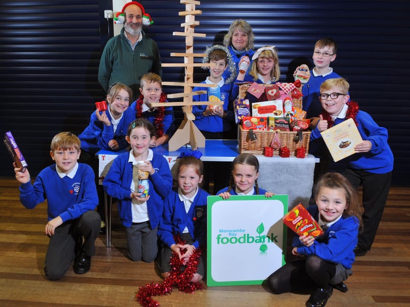Annette Smith and Roger Gittings of Morecambe Bay Foodbank and Torrisholme school pupils doing a reverse advent calendar for Christmas.