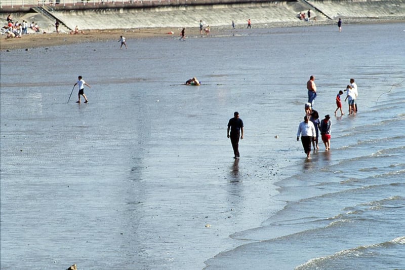 Paddling in the tide. The former Polo Tower can be seen in the background.