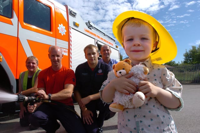 Beau McCombie, two, with his teddy bear, which was rescued from a tree in Happy Mount Park during the recent teddy bears picnic, by Lancaster City Council's tree surgeon, Neil Morris, (left) and assistant operations manager Kevin Kilifin, (right), pictured with Morecambe station fire fighters, Sam Westworth and Simon Walker from White Watch.