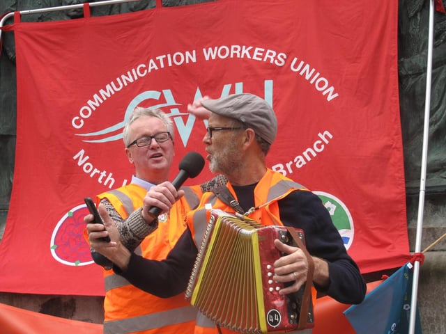 Musician Pete Moser and L&M TUC president Eugene Doherty lead a song.