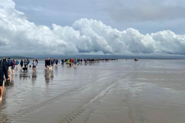 Hundreds of hardy hikers braved freak weather conditions to complete the Cross Bay Walk.