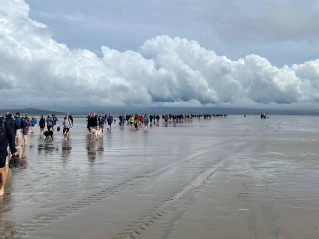 Hundreds of hardy hikers braved freak weather conditions to complete the Cross Bay Walk.
