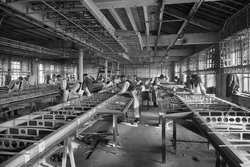 Workers constructing the framework for biplane wings in January 1917 at the Waring and Gillow factory. Photographer: H Bedford Lemere.