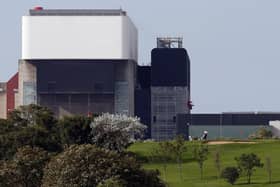 Golfers are pictured on a course against the backdrop of EDF's Heysham 2 Nuclear Power Station in north-west England, on September 24, 2008. AFP PHOTO/PAUL ELLIS (Photo credit should read PAUL ELLIS/AFP via Getty Images)