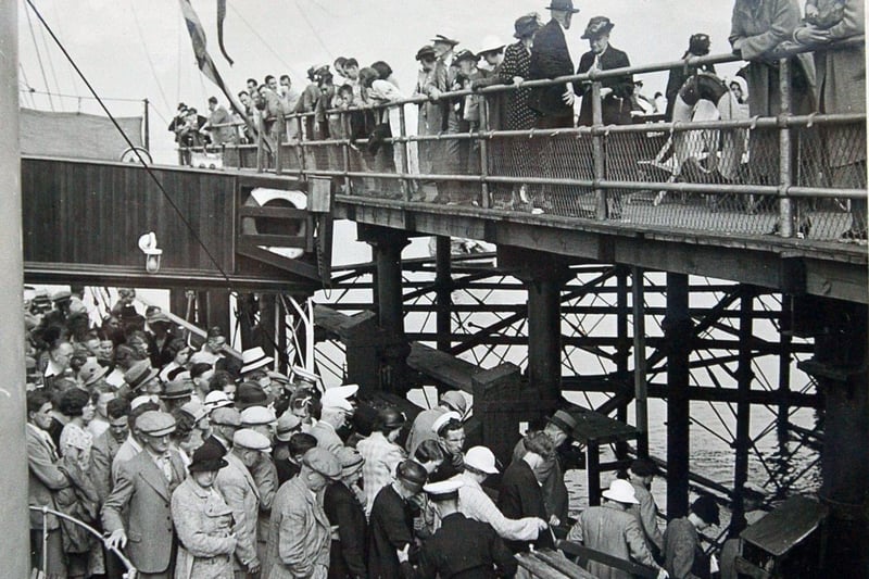 Crowds queue for boat trips to and from Morecambe's Central Pier.