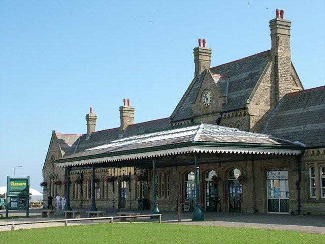 Morecambe Promenade Station was built by the Midland Railway Company as the terminus of the former “little” North Western Railway to exploit the numbers of holidaymakers moving between Morecambe, Heysham and Lancaster, and to provide a speedy service for port workers. Morecambe Promenade Station first opened to passengers in 1907 and had four main platforms and a goods siding. By the late 1980s tourism in Morecambe was rapidly declining. The station had remained largely unaltered and was far too large for the one to two trains per hour it now received. In 1993 the decision was taken to close Promenade Station and replace it with a new station situated slightly further inland and closer to the town centre. After closure the station building remained intact. The Morecambe Visitor Information Centre was based in the station from 1992 until its closure earlier this year. In 1997 it became the live entertainment venue and adjoining pub we still see today.