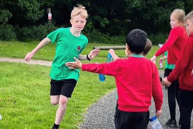 Connor Poole completes the final mile of his marathon challenge, supported by his fellow Bowerham School pupils.