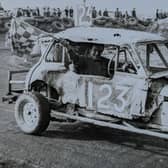 Gerald Hoggarth waves the chequered flag from his stock car number 123.