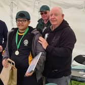 Qais being presented with his Fishing Achievement Medal by Duncan Smith and Harry Cox