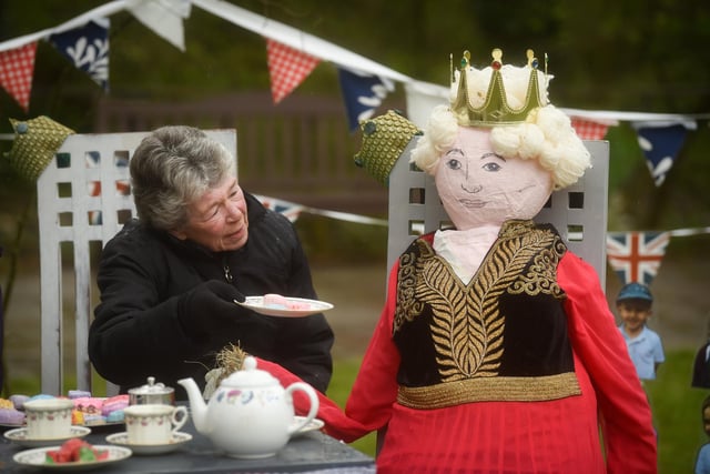 Margaret Gornall offers a piece of cake to the Queen.