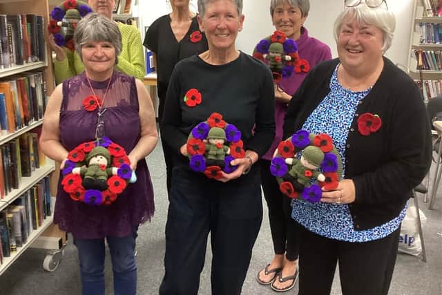 Wreathed in pride: The knitters pictured with FirstLight Trust’s Lara McDonnell, centre back row. Picture by Ken Bennett.