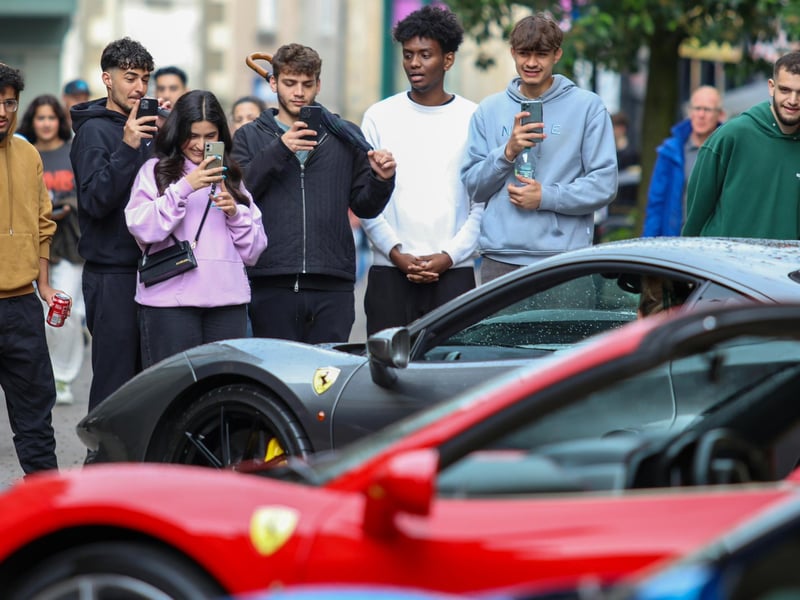 Festival-goers taking photos of the Ferraris in Lancaster for Festa Italia.