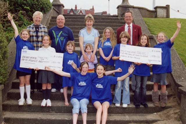 Children from Fleetwood Swimming Club with Brian House Friends Group and Fleetwood Lions representatives at the presentation of funds raised during a swimathon