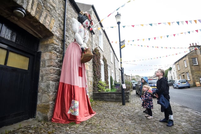 Youngsters admire one of the village's giant scarecrows.