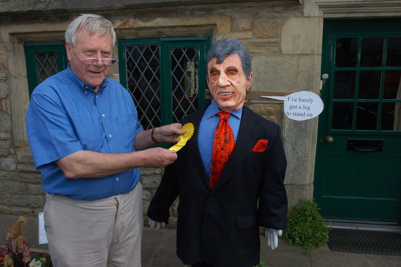 John Ryle puts the yellow rosette for third prize on Gordon Brown in The Election at Wray Scarecrow Festival in 2010.