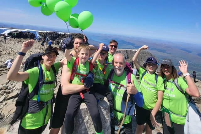 Oscar Burrow, 6, from Lancaster, has climbed the UK's 12 highest mountains, the equivalent of scaling Mount Everest, to raise money for Derian House Children’s Hospice so that poorly children and their families can have a holiday. He is pictured centre with family and friends at the top of Ben Nevis