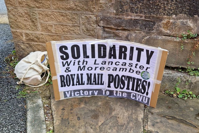 A banner on display at the Royal Mail workers' strike in Lancaster.