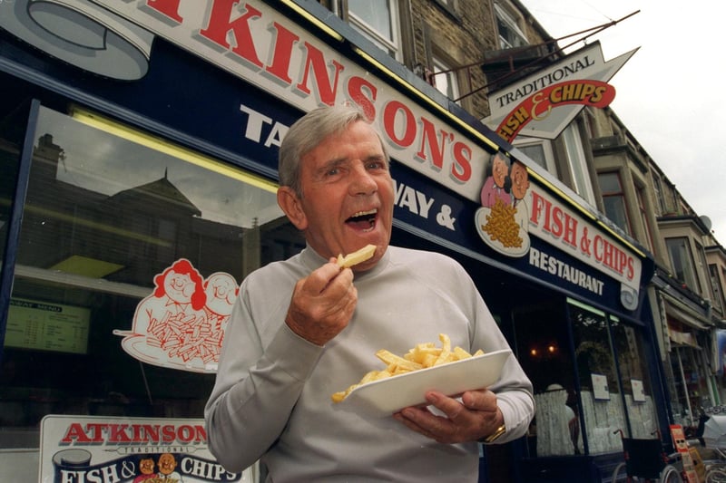 The late comedian Norman Wisdom enjoys a chippy tea from Atkinson's Fish & Chips in Albert Road, Morecambe, in August 1996.