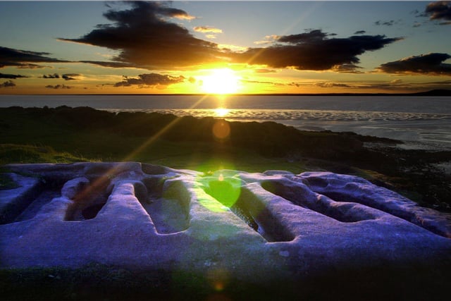 The sun sets on the stone coffins at Heysham Head.