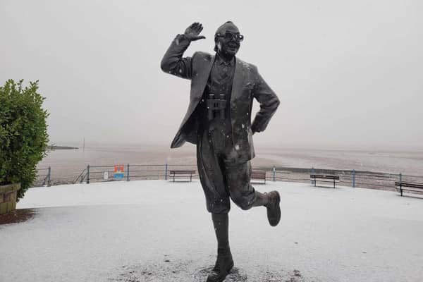 Snow falls on the Eric Morecambe statue.