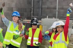 Bowerham Community Primary School pupils helps lay bricks to the final wall of the Energy Centre at the Royal Lancaster Infirmary.