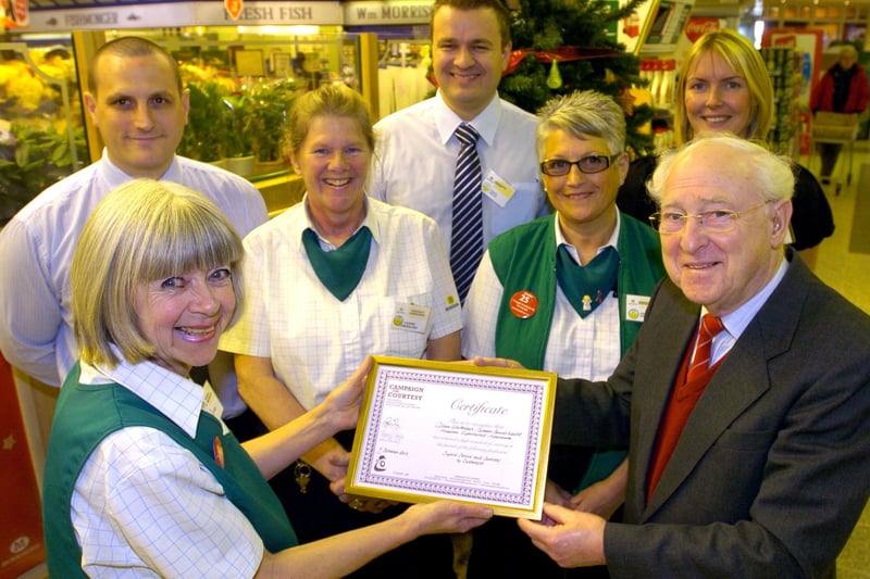 Customer services assistant Gillian Whittaker receives her certificate awarded for superb service and courtesy to customers from Alan Coles, North West assistant regional executive for the National Campaign for Courtesy, watched by colleagues at Morrisons Morecambe.