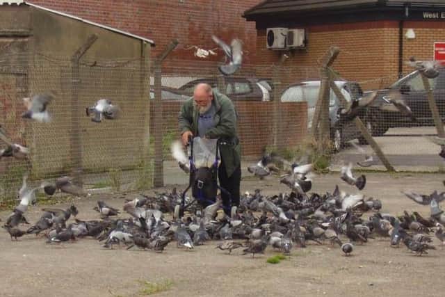 John Wilkinson feeding his beloved pigeons in Morecambe.