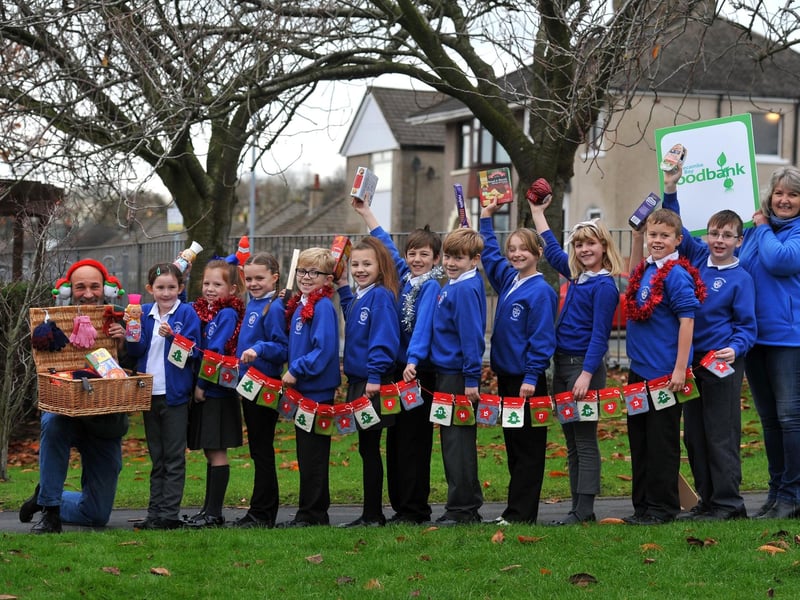 Annette Smith and Roger Gittings of Morecambe Bay Foodbank and Torrisholme school pupils doing a reverse advent calendar for Christmas.