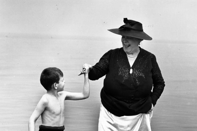 Music hall singer Florrie Ford and her young companion enjoy a paddle in the sea at Morecambe in August 1939.