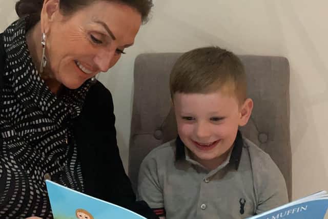 Liz Ashby shares her new book with her grandson, Parker.